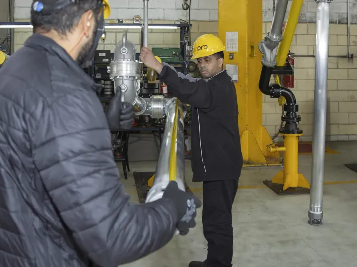 Dois profissionais da TSPro avaliando um equipamento em conjunto